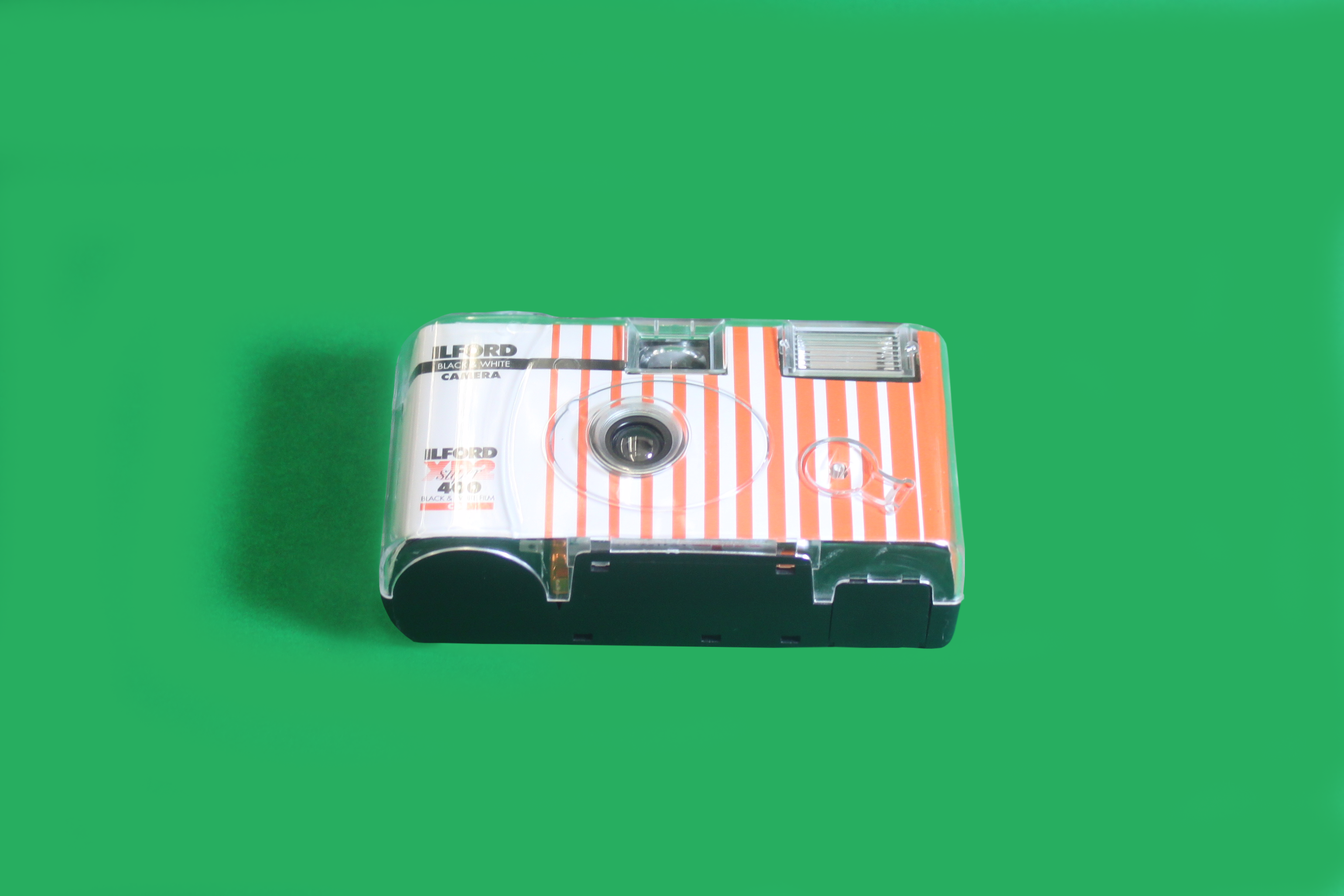 A small camera lies atop a green table.